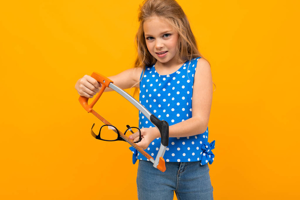 petite fille intelligente posant avec des lunettes sur fond orange
   - Photo, image