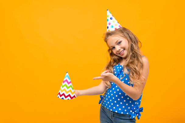 little smart girl posing with gift against orange background   - Photo, Image