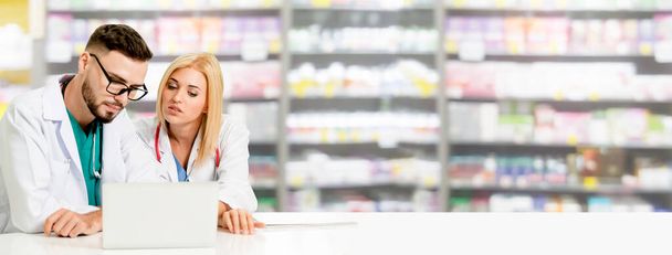 Pharmacist working with computer in pharmacy. - Photo, Image
