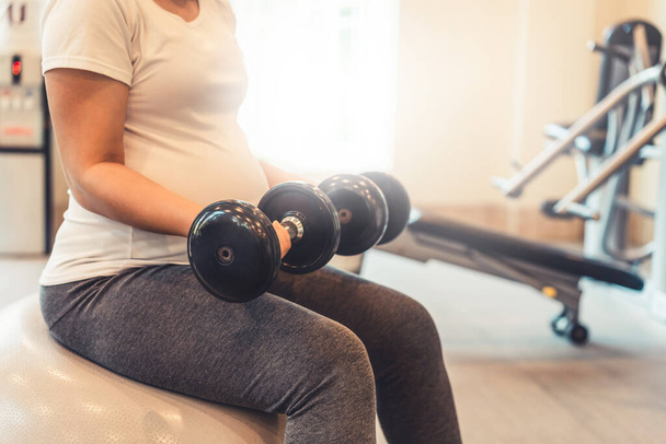 Active pregnant woman exercise in fitness center. - Fotoğraf, Görsel