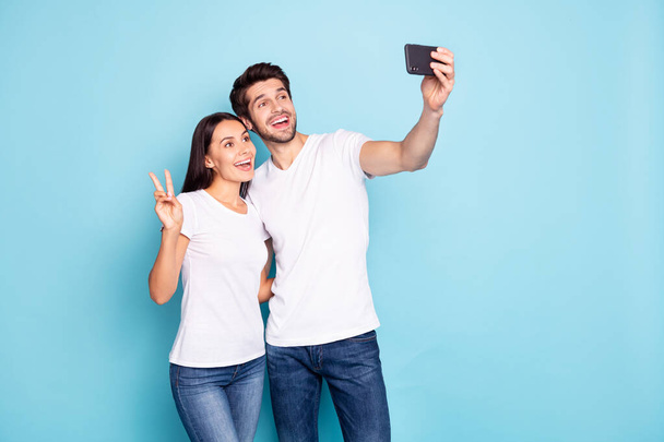 Portrait of his he her she nice attractive lovely funny glad excited cheerful cheery couple hugging making selfie showing v-sign isolated on bright vivid shine vibrant blue turquoise background - Zdjęcie, obraz
