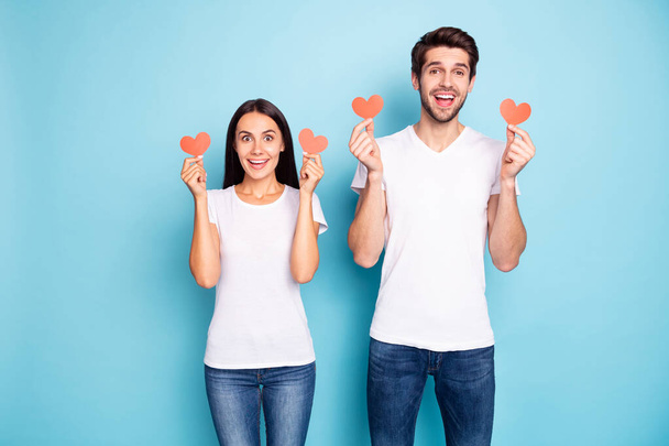 Portrait of his he her she nice attractive lovely funny funky cheerful cheery glad couple holding in hands small little hearts isolated on bright vivid shine vibrant blue turquoise background - Zdjęcie, obraz