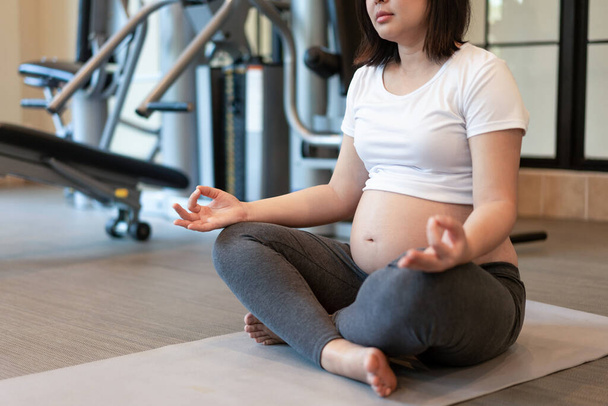 Aktiivinen raskaana oleva nainen liikunta kuntokeskuksessa. - Valokuva, kuva