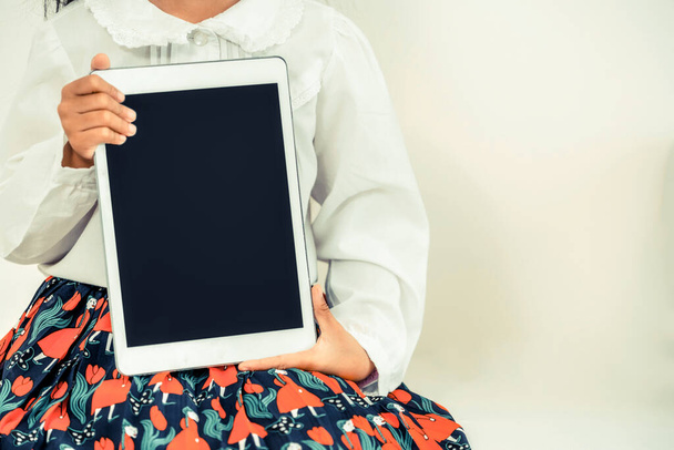 Kid girl showing black screen of tablet computer. - Фото, изображение