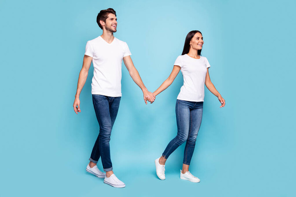 Full length body size view of his he her she nice attractive cheerful cheery spouses holding hands walking spending weekend isolated over bright vivid shine vibrant blue green turquoise background - Foto, Imagen