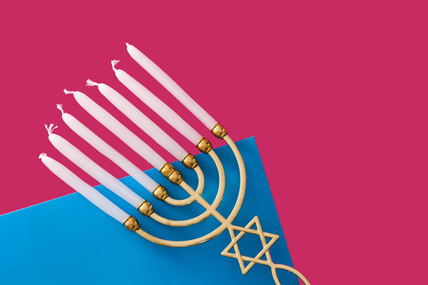 Jewish Hanukkah menorah on pink and blue background - Foto, afbeelding
