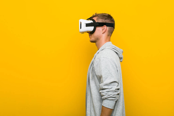 Giovane uomo caucasico utilizzando un occhiali realtà virtuale
 - Foto, immagini