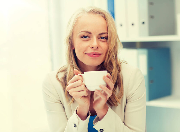 happy businesswoman drinking coffee at office - Φωτογραφία, εικόνα