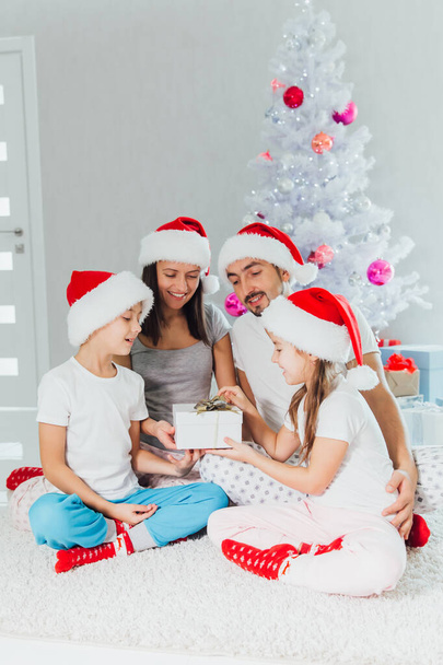 Happy parents and children near Christmas tree at home - Foto, Imagen