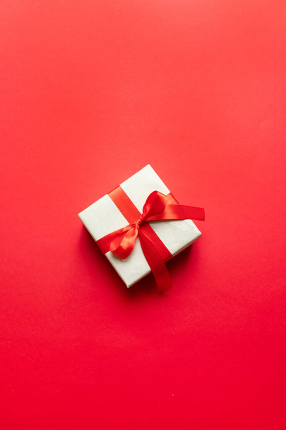 Minimal New Year concept. Christmas composition with festive red craft box and red ribbon - 写真・画像