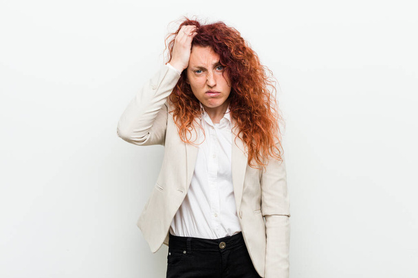 Young natural redhead business woman isolated against white background being shocked, she has remembered important meeting. - Valokuva, kuva