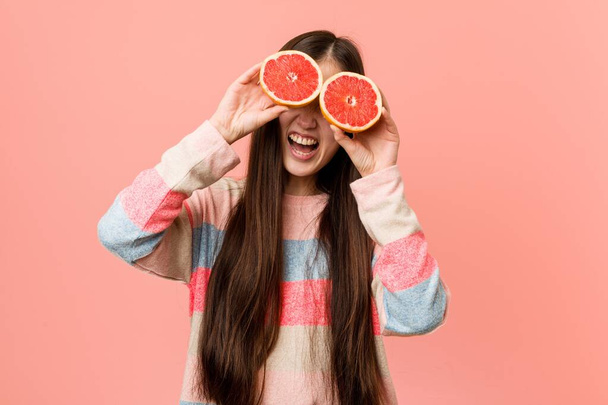 Young asian woman playing with a grapefruit - Fotó, kép