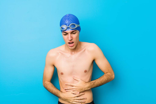Jeune nageur malade, souffrant de maux d'estomac, concept de maladie douloureuse
. - Photo, image
