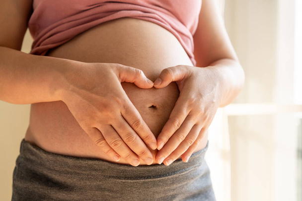 Happy pregnant woman and expecting baby at home. - Valokuva, kuva