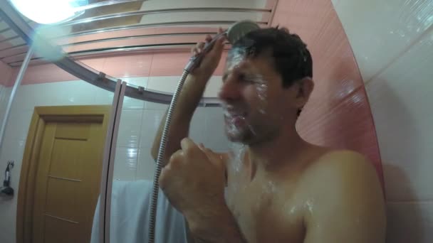 Mężczyzna myje się pod prysznicem i śpiewa. - Materiał filmowy, wideo
