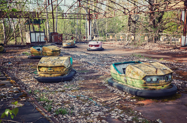 abandoned bumper cars in ruined amusement park in Pripyat city, Exclusion zone of Chernobyl, Ukraine - Photo, Image