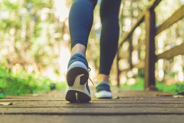 女性ランナーの足は自然の中を歩く。靴を閉じてください。健康的なライフスタイルフィットネスコンセプト. - 写真・画像