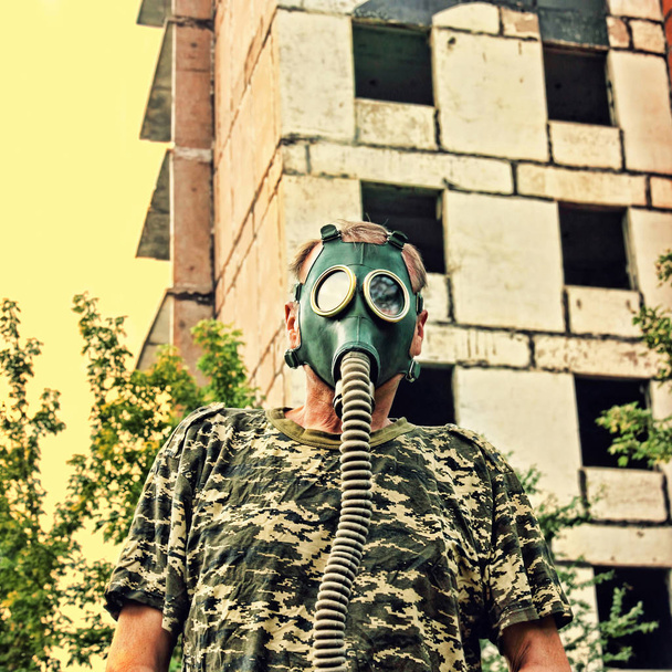 Men in gas mask against the ruined building. Apocalyptic concept - Foto, imagen
