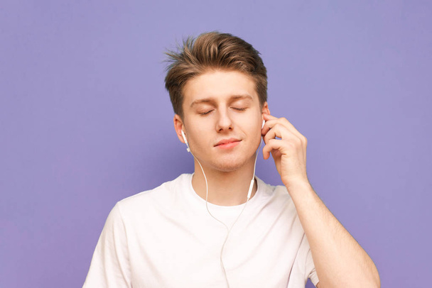 Close-up portrait of a guy listens to music in his headphones wi - Foto, afbeelding