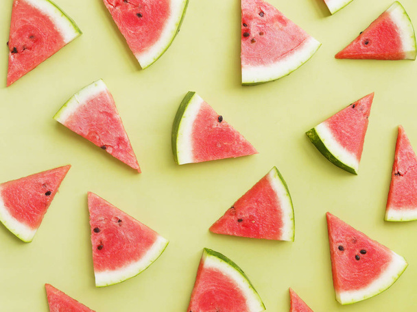 Watermelon slices on a green background pattern, top view, flat layout - Foto, immagini