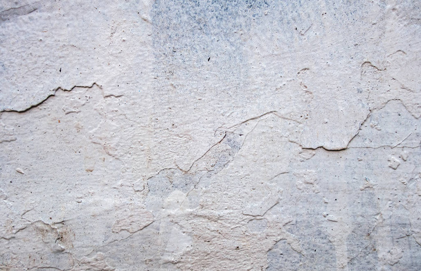 repeatedly painted concrete wall with old gray paint peeking out from under the white - Photo, Image
