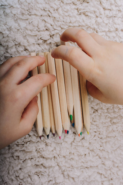 Рука тримає кольорові олівці для творчої ідеї та концепції
.  - Фото, зображення