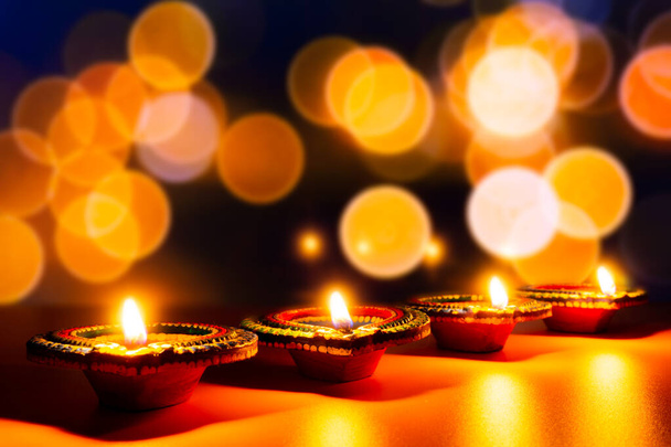 Indyjski festiwal Diwali, Diya lampy olejne oświetlone na kolorowe rangoli.  - Zdjęcie, obraz