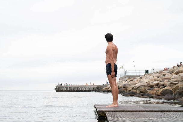 férfi áll a sétányon úszás előtt - Fotó, kép