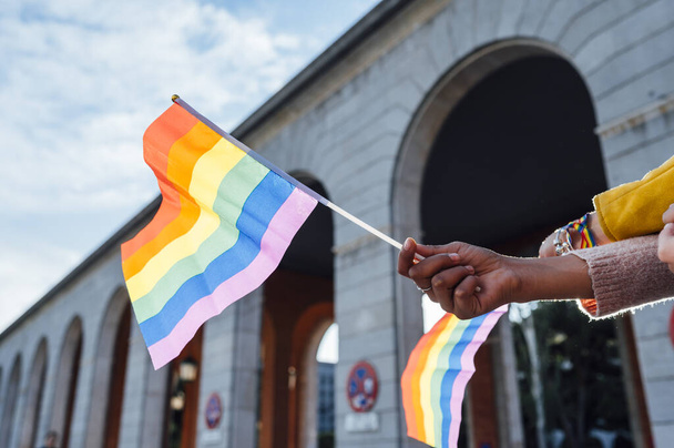 Ręce kobiet z flagą dumy gejów - Zdjęcie, obraz