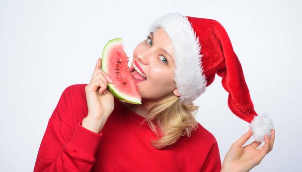 Exotic christmas celebration. Christmas summer destinations. Tropical christmas concept. Travel vacation and holidays resort. Christmas girl eat watermelon. Woman santa hat hold slice watermelon - Foto, afbeelding