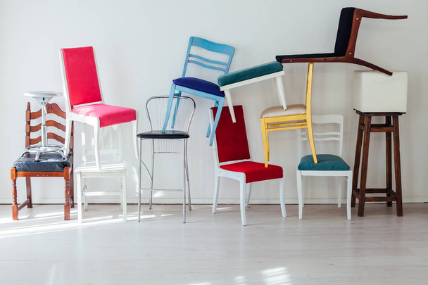 Много разноцветных стульев в интерьере белой комнаты
 - Фото, изображение