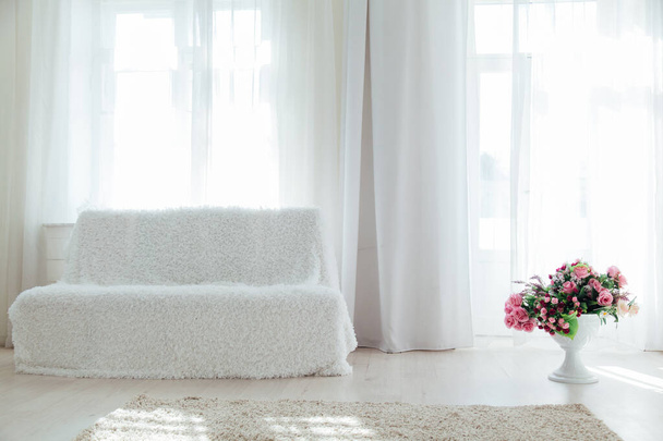white sofa with flowers in the interior of the room with windows - Fotografie, Obrázek