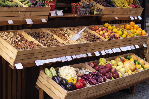 A gyümölcsös standnál. Friss, egészséges ökológiai gyümölcsök, zöldségek, diófélék a termelői piacon - Fotó, kép