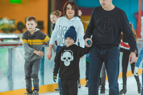 LVIV, UKRAINE - 3 février 2019 : père enseignant à son fils à patiner sur la patinoire
 - Photo, image