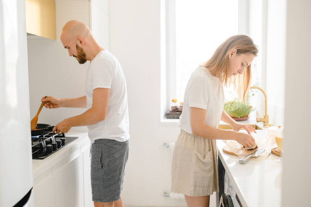 husband and wife cooking in the kitchen - Фото, зображення