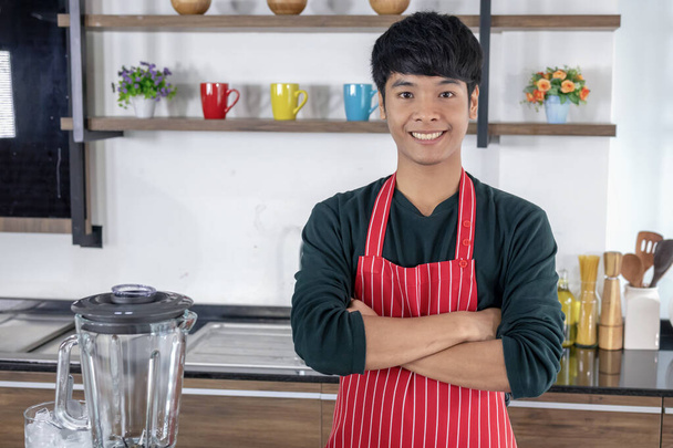 Portret van een gelukkige jongeman in de keuken - Foto, afbeelding