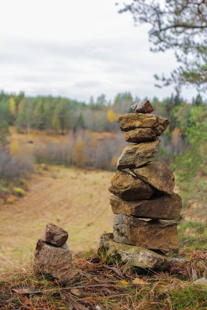 pyramid of stones. autumn landscape. trees with yellowed leaves. time for walks - Photo, Image