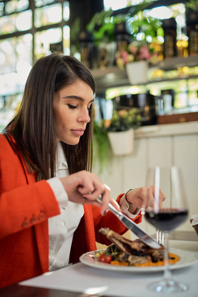 Empresária caucasiana atraente sentada no restaurante e almoçando
. - Foto, Imagem
