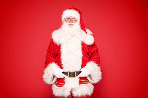 Настоящий Санта-Клаус на красном фоне студии
. - Фото, изображение