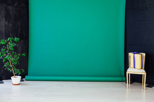 μία καρέκλα με δώρο στο εσωτερικό του δωματίου με πράσινο φόντο - Φωτογραφία, εικόνα