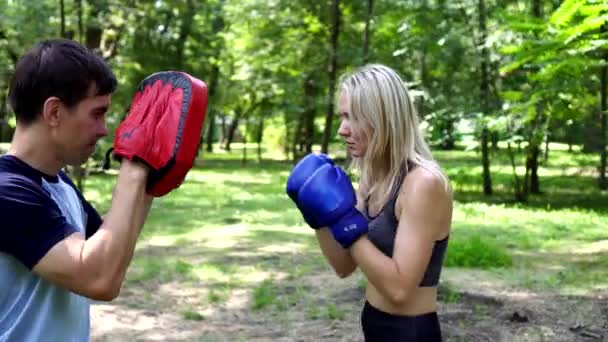 Boks eldivenli bir kadın boks antrenörüyle antrenman yapıyor.. - Video, Çekim