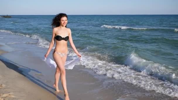 Tropik adada dinlenen kıvırcık saçlı baştan çıkarıcı bir kadın sahilde koşan güzel bir kız, mutlu bir kadın. - Video, Çekim