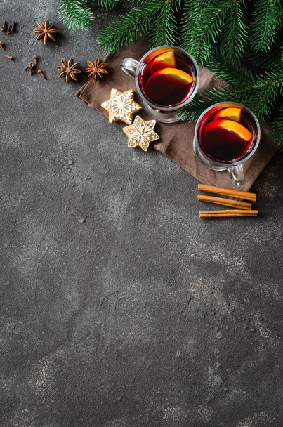 Χριστουγεννιάτικο κόκκινο κρασί με μπαχαρικά σε σκούρο σκυρόδεμα φόντο - Φωτογραφία, εικόνα