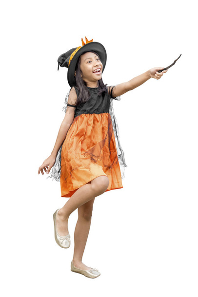 Asian girl in witch costume holding a magic wand - Fotoğraf, Görsel
