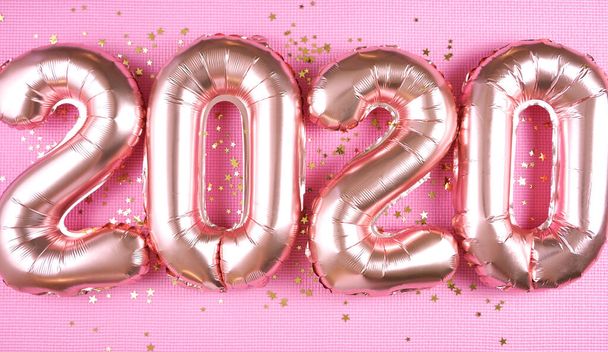 Happy New Years Eve rosa lámina de oro 2020 globos metálicos sobre fondo rosa
. - Foto, imagen