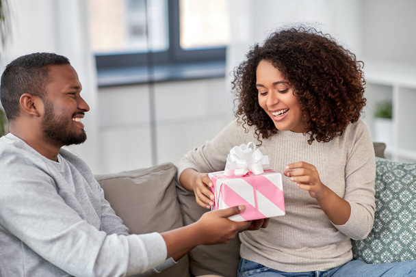 happy couple with gift at home - Foto, Imagen