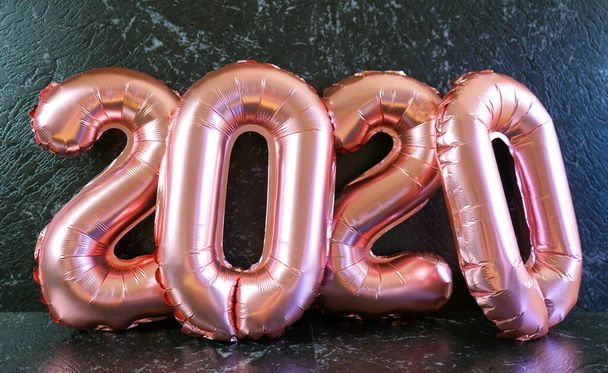 Víspera de Año Nuevo 2020 número globos metálicos sobre tabla de fondo de mármol negro
. - Foto, imagen