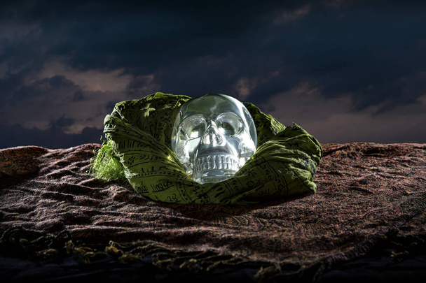 Scary or creepy glowing crystal skull on Halloween holiday or Dia De Los Muertos Day of the Dead festival.  Depicts horror theme and superstition.  - Photo, image
