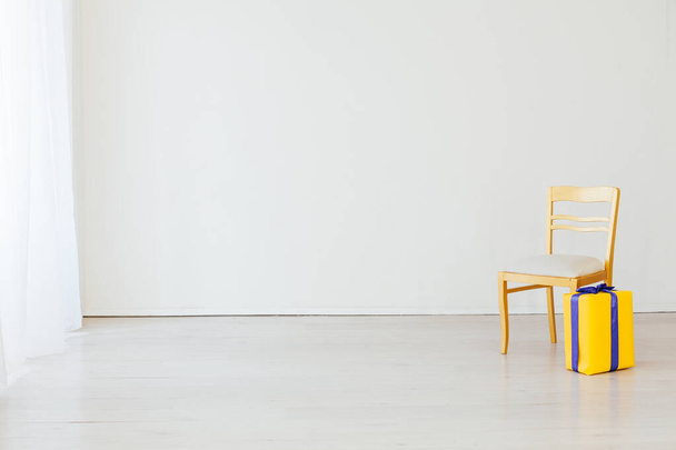 один стул с подарком в интерьере белой пустой комнаты
 - Фото, изображение