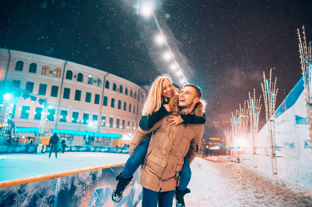 Fröhliches und verspieltes Paar im warmen Winteroutfit tummelt sich - Foto, Bild